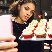 woman taking a selfie with vanilla cupcakes woman taking a selfie with vanilla cupcakes