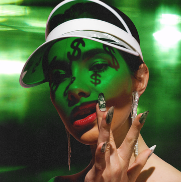Money kink a woman in green light with dollar signs shadowed on her face and dollar bill nail art